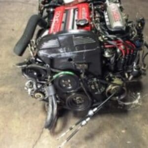 JDM Mitsubishi 4G63T turbo engine with red valve covers and black components.