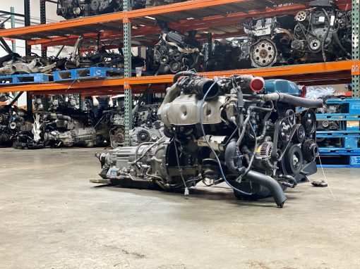 Automotive engine on warehouse floor at Prime Forge Motors.